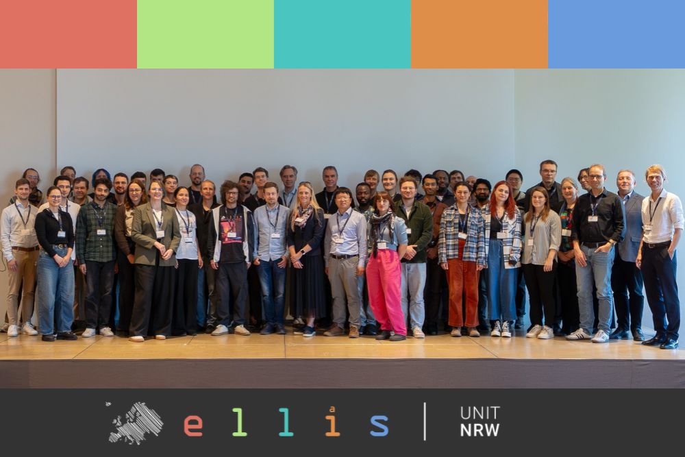 Group photo of researchers and participants at the ELLIS Unit NRW AI research kick-off in Siegburg, standing on a stage beside an ELLIS banner.